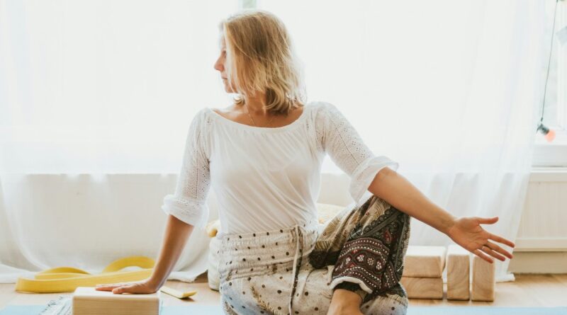 Frau in einer hellen Wohnung bei einer ruhigen Übung auf der Gymnastikmatte