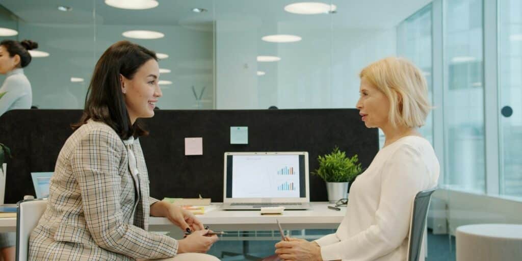 Zwei Frauen besprechen im Büro einen Projektplan am Schreibtisch